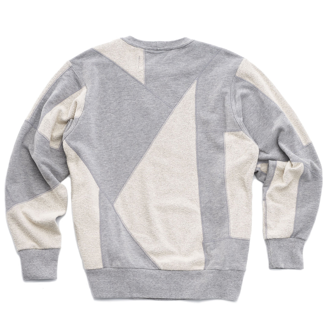 An upcycled crewneck sweater with heather grey and white pieces combined to make a unique geometric pattern.