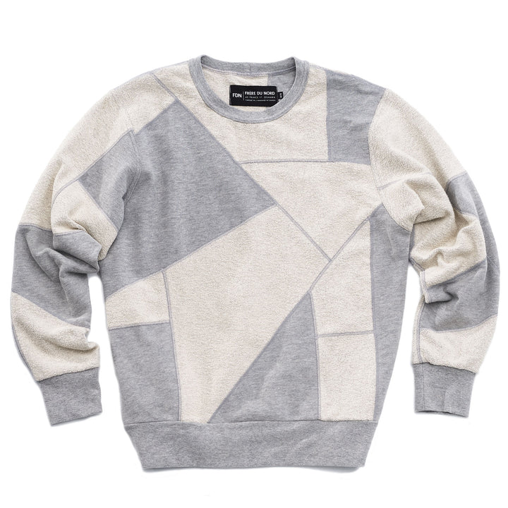 An upcycled crewneck sweater with heather grey and white pieces combined to make a unique geometric pattern.