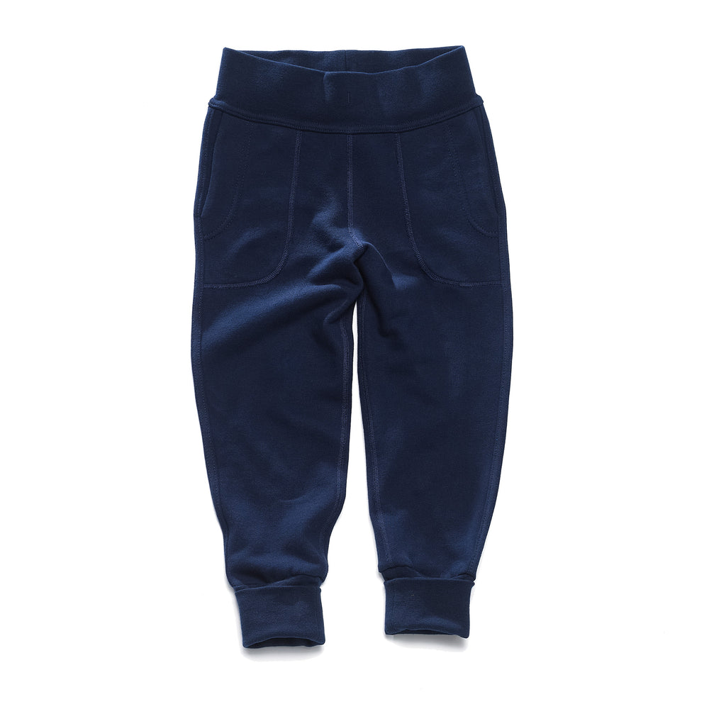 A pair of navy children's pants with flatlocked seams, top stitched waistband, and  grow with me cuffs rolled up slightly.