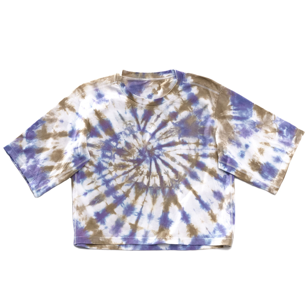 A tie-dyed crop t-shirt featuring a bright violet-blue and desert brown color pattern, with long sleeves and a round neckline.
